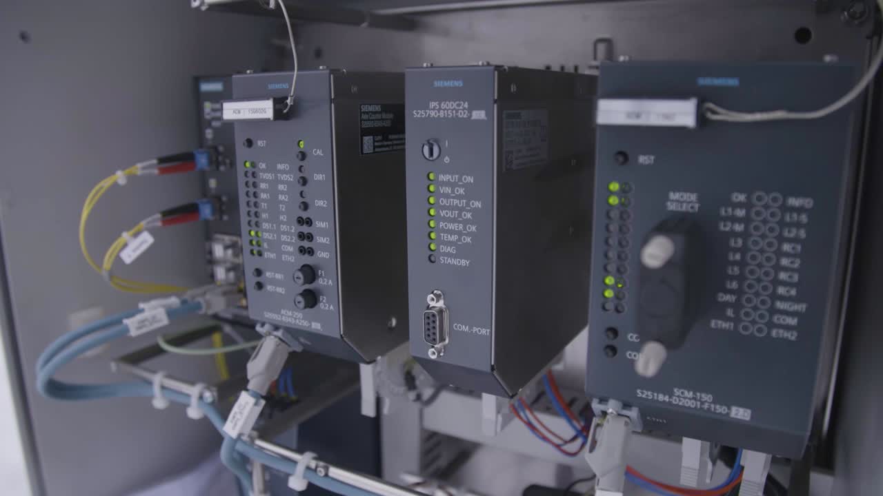 Industrial control panel with Siemens hardware showing various status lights and cable connections