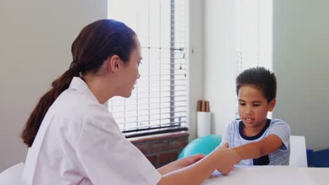 Fisioterapeuta-Femenina-Dando-Masaje-De-Manos-A-Paciente-Niño-4k