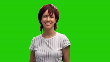 portrait of happy woman showing victory sign on green background