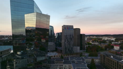 aerial evening sideways flying shot of new urban area with tall shiny glass buildings in vilnius, lithuania.constitution prospectus with city traffic are visible. high quality 4k prores footage.