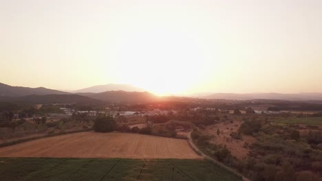 Aerial-drone-shot-flying-up-showing-a-magnificent-sunset-over-fields-being-watered