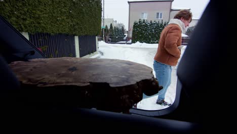 Blick-Aus-Dem-Kofferraum-Eines-Autos-Auf-Einen-Mann,-Der-Einen-Holztisch-Im-Innenraum-Zurücklässt