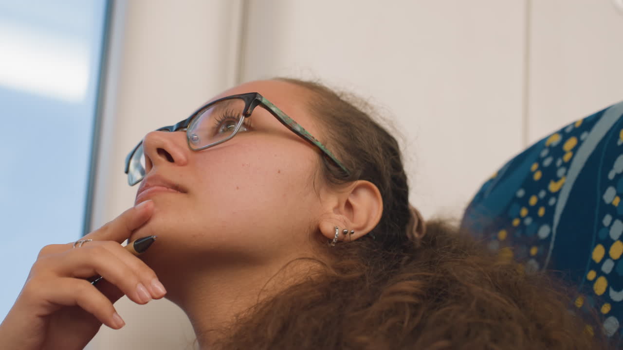 Studente rilassato che ripassa gli appunti durante il tragitto. Allievo soddisfatto che riflette sul materiale mentre torna a casa. Studente contento che studia con calma gli appunti con un sorriso delicato durante il viaggio in treno.