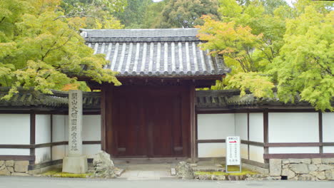 wooden gate entrance on the side of a road in kyoto, japan soft lighting