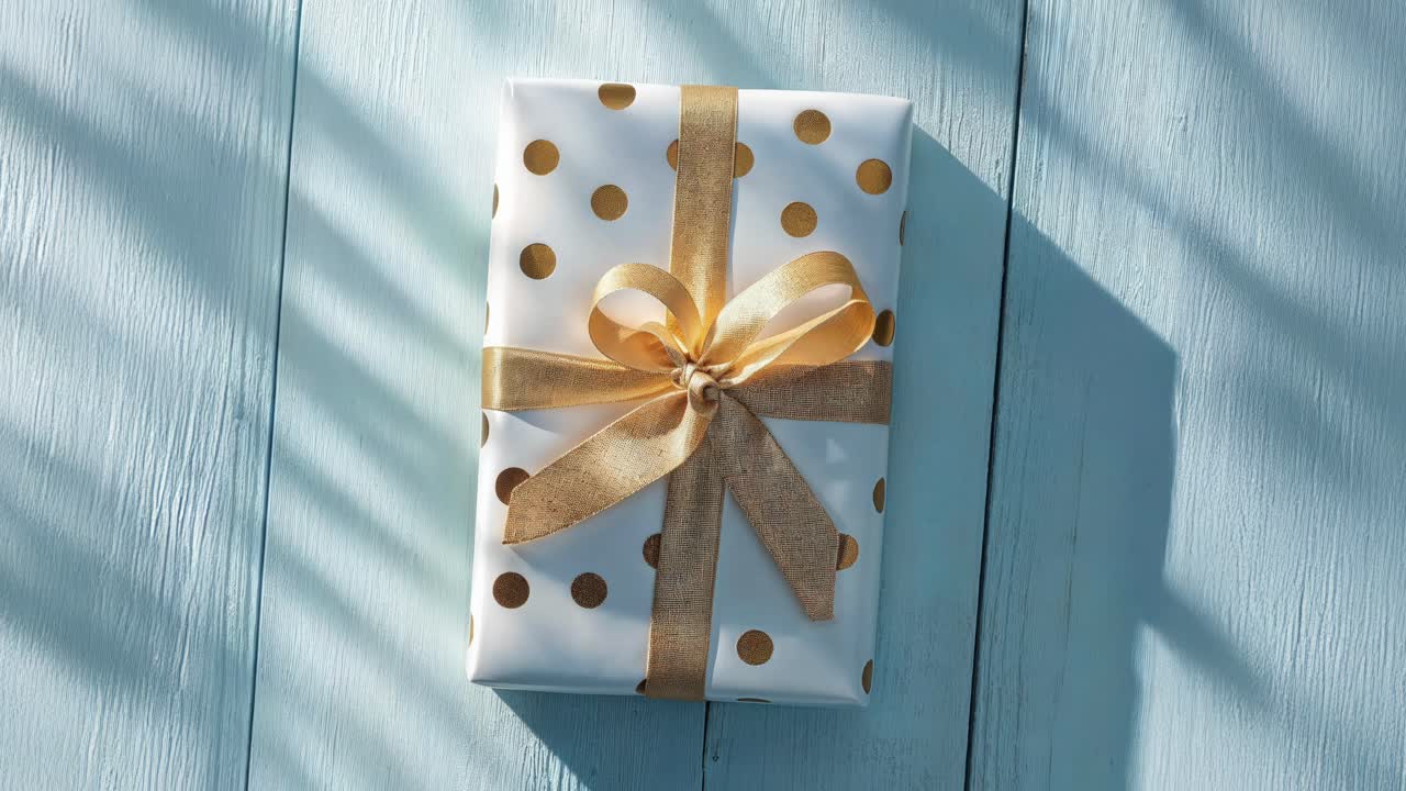 Gift wrapped in white paper with gold ribbon and bow