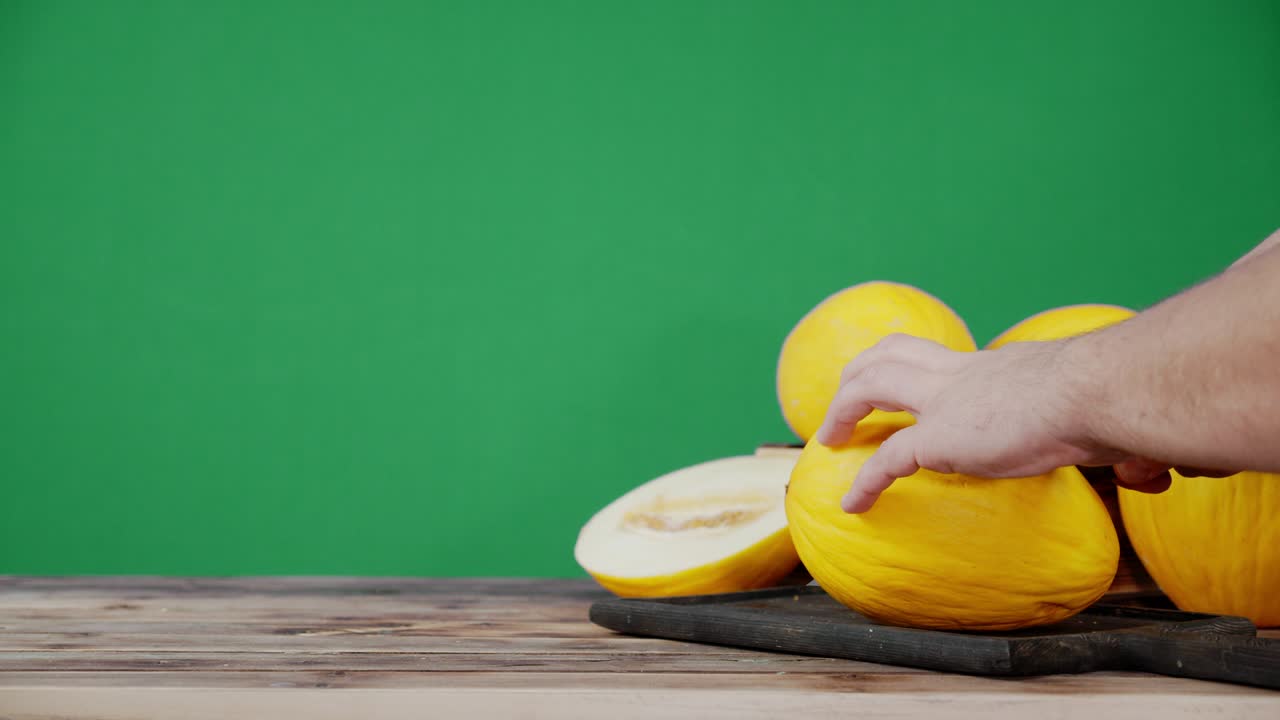 las manos cortan el melón en dos mitades.