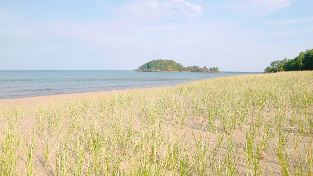 Dune grass blowing in a soft breeze on a sandy beach of Lake Superior. Shot in 4k