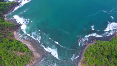 drone video tilting up from a small gap between islands to reveal beautiful blue water of the pacific ocean off the coast of costa rica