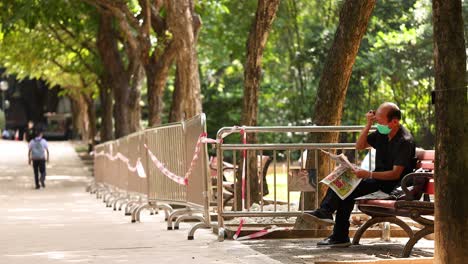 man reading newspaper in park