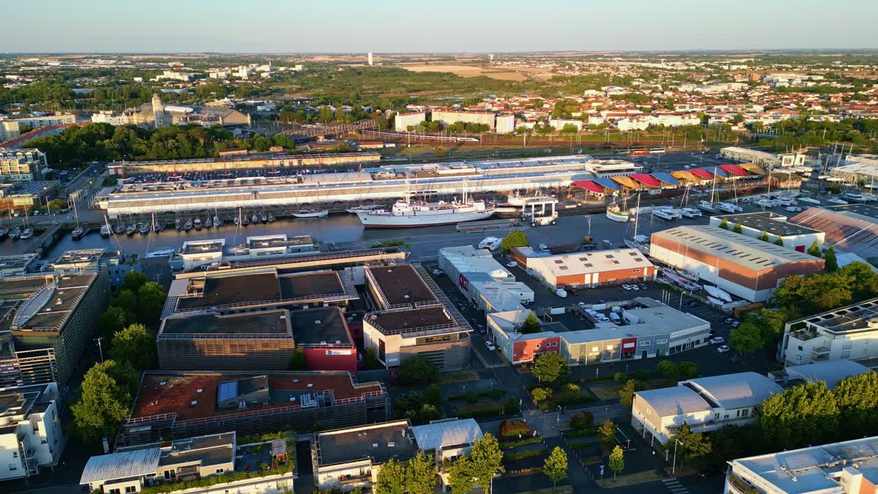 Quai Louis Punier of the Maritime Museum and Pontoon with large warehouses, hangars, and green trees around buildings from above, La Rochelle, Charente-Maritime, France