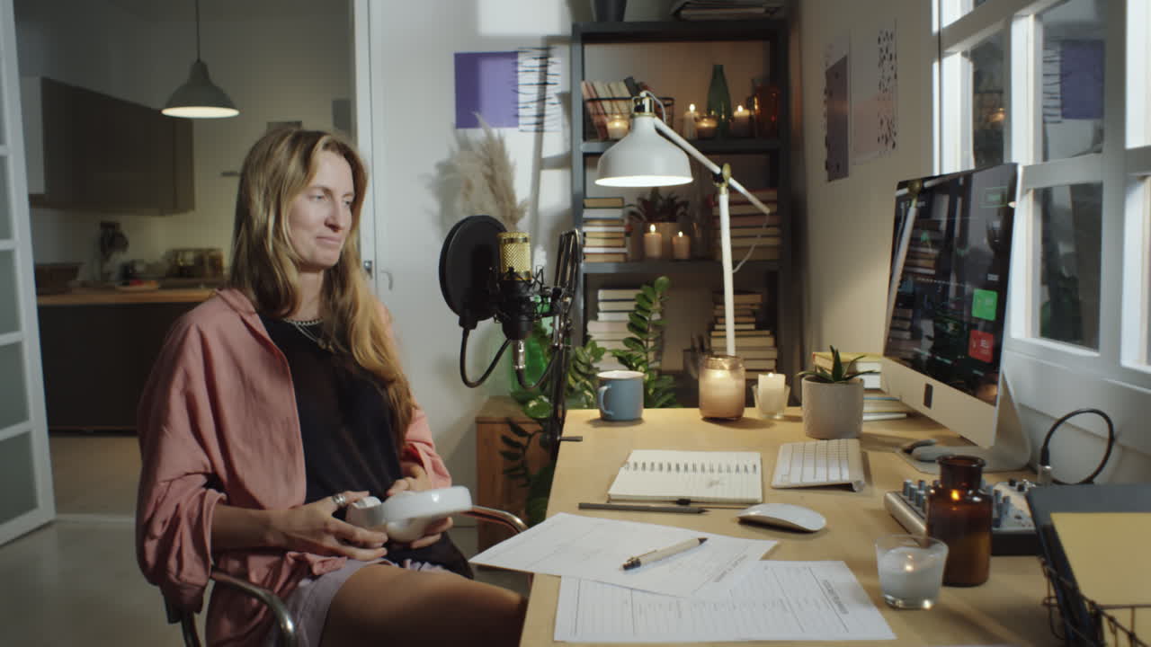 Blogger che registra un podcast nel suo accogliente studio di casa