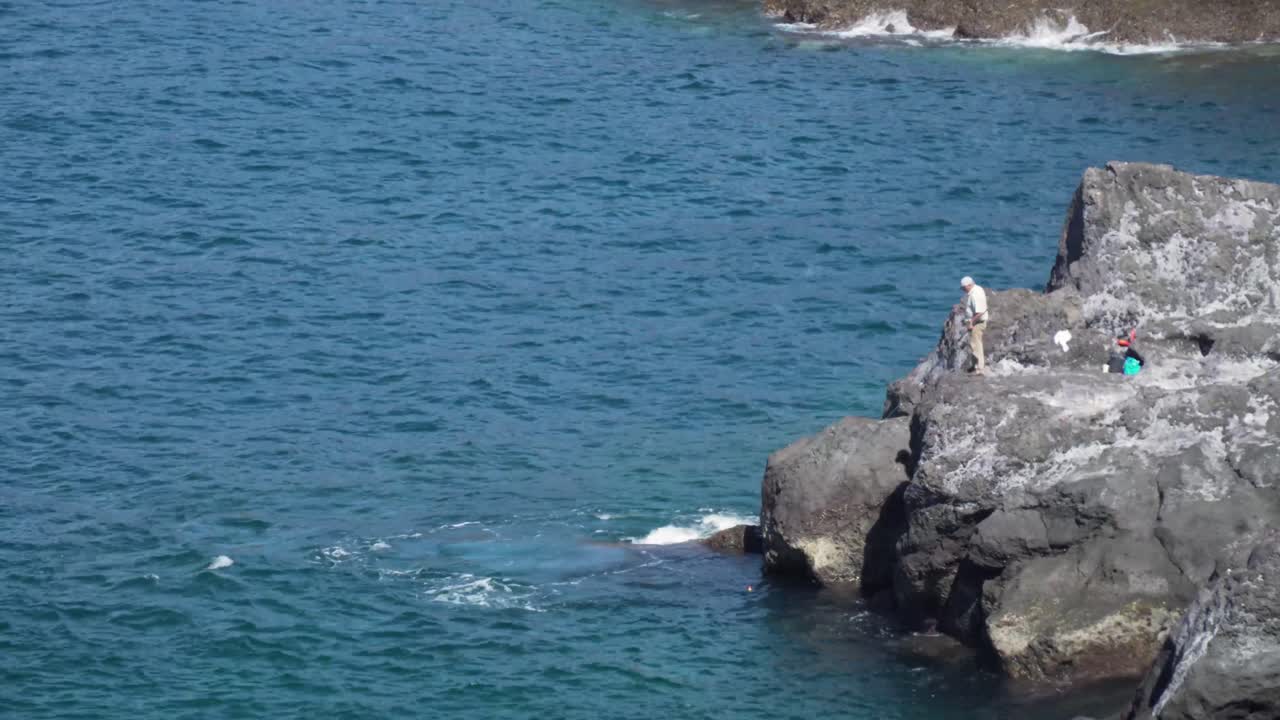 해안 바위에서 시하는 어부