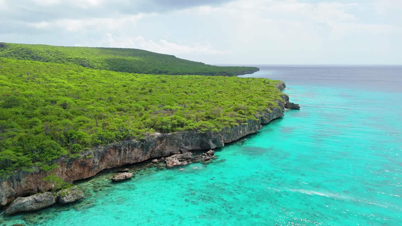 카리브해 쿠라소 섬 의 플라야 포르토 마리 근처 에 있는 멋진 절벽 을 보여 주는 드론 의 상승