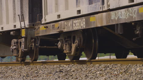 Cerca-De-Ruedas-De-Tren-De-Movimiento-Lento-Rodando-A-Lo-Largo-De-Las-Vías-Del-Tren-Cinturón-De-óxido