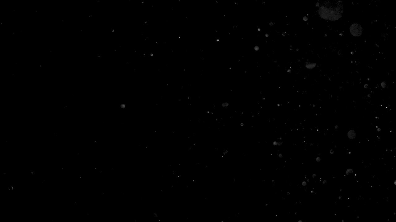 Real Slow Motion Dust Particles Floating on Dark Black Background. Use Add Screen Mode for Compositing Asset VFX to Create Your Scene ProRes 4K.