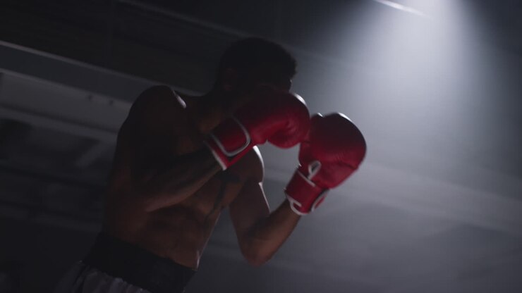 Close Up Shot Of Two Male Boxers Wearing Gloves In Boxing Ring Fighting In Boxing Match With Low Key Lighting 3