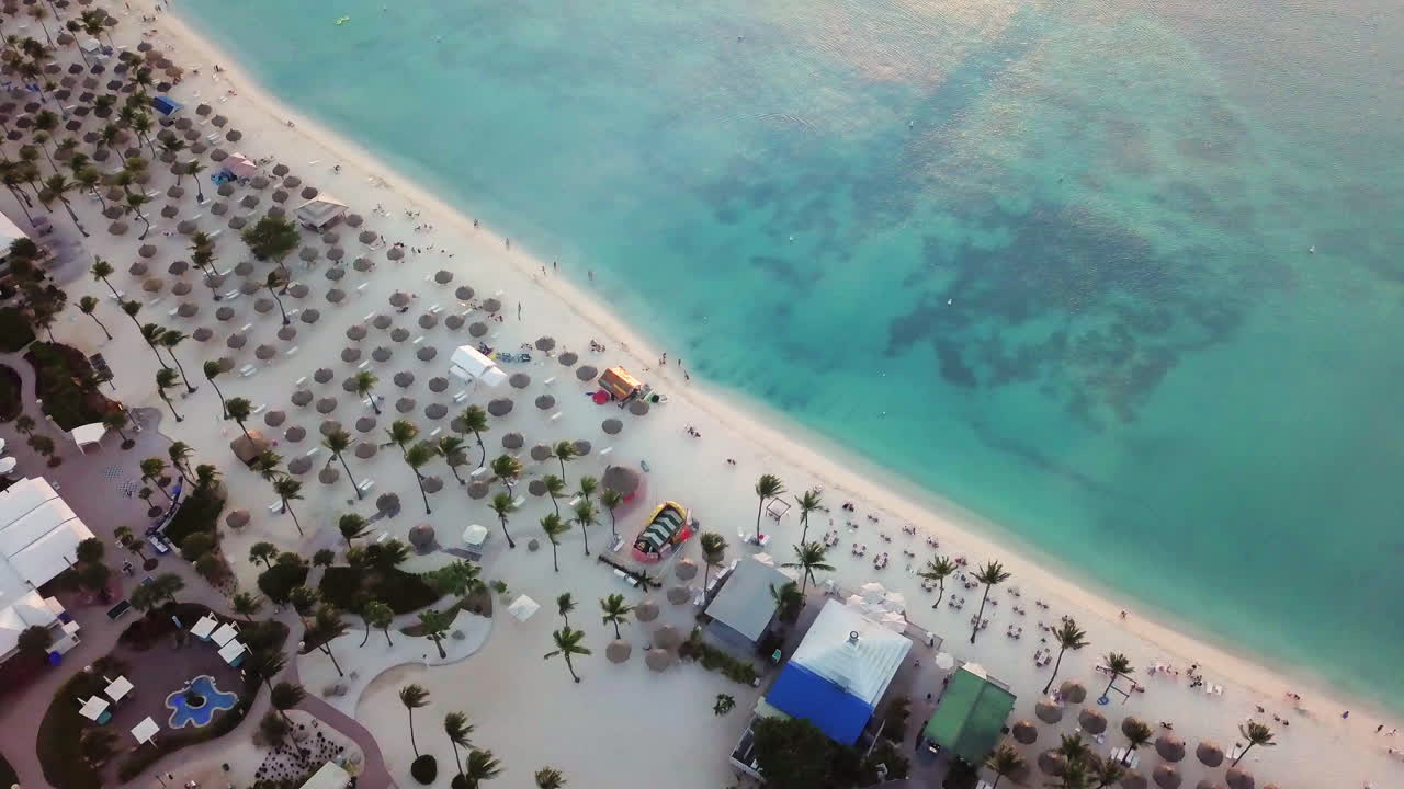 algunas personas caminan por la playa junto al mar caribe azul en palm beach, aruba
