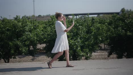 woman walking in an orchard using a tablet