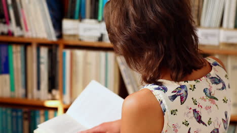 Young-female-student-reading-in-library-