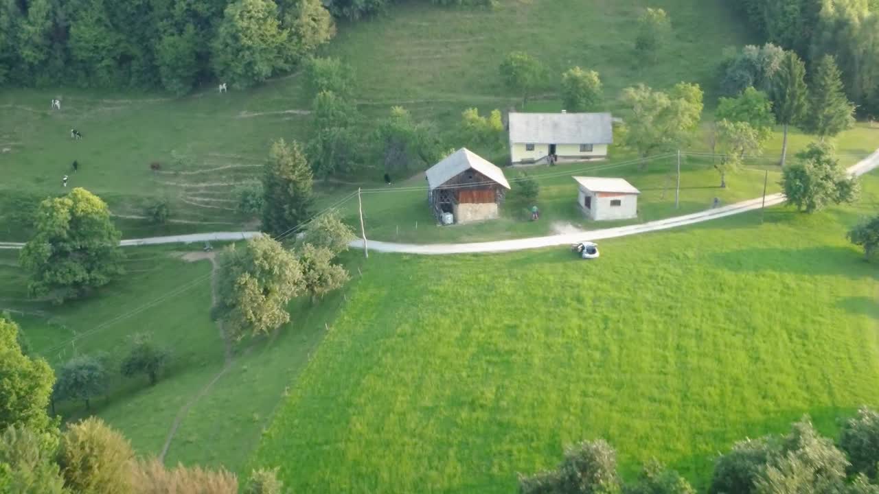 Old family houses with barns up in hills surrounded with meadows and green spruce trees