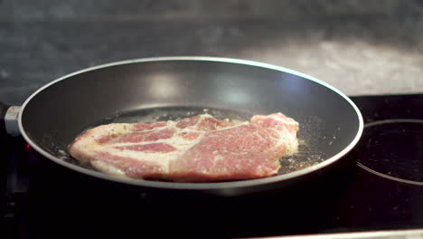 cocinar un filete de cerdo frito en una sartén en la cocina