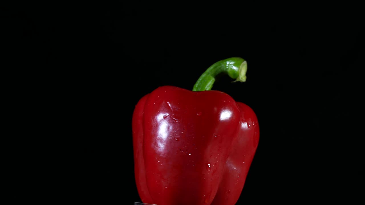 Bell pepper turning on black background