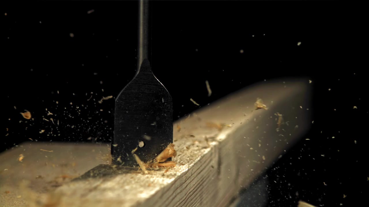 Slow Motion Close-up of a Drill Bit Cutting into Wood