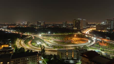el lapso de tiempo de la vista aérea de la carretera de la carretera en el horizonte del centro de bangkok, tailandia. distrito financiero y centros comerciales en la ciudad urbana inteligente en asia. rascacielos y edificios de gran altura por la noche
