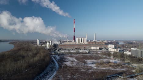 aerial drone fly approaching thermal power plant, smoking chimney over skyline