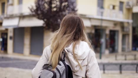 a woman walks along a city street with backpack, a tourist looks around at the sights