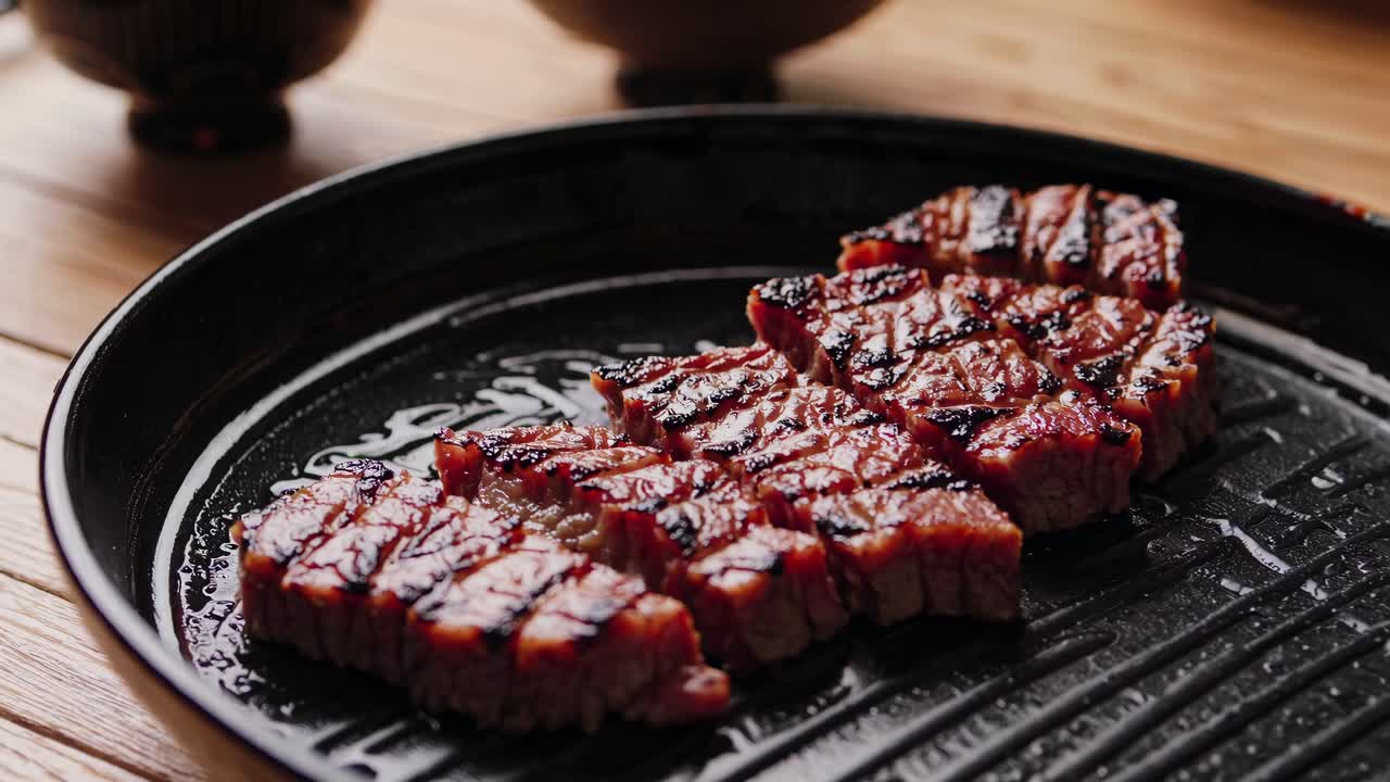 木製のテーブルに焼き肉、ご飯、野菜が並んだ日本食の真上から撮影した動画