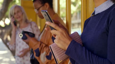 commuters using mobile phone at bus stop 4k