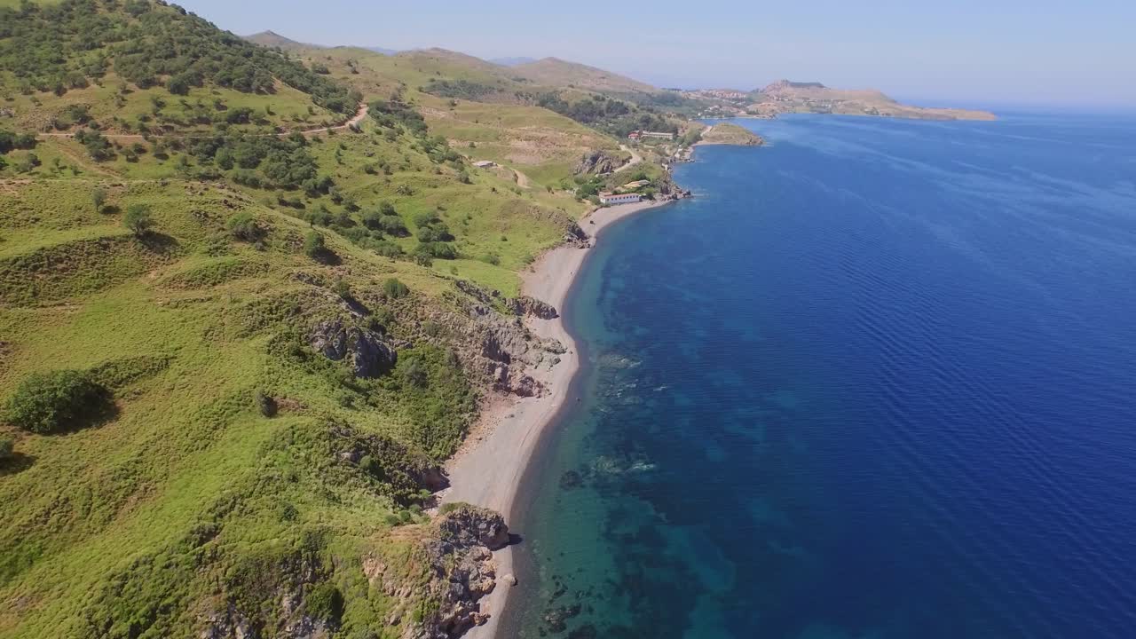 Aerial: A quiet beach with a fishing boat on Lesbos, near Turkey