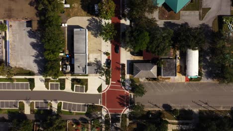 Drone-top-down-bird's-eye-view-of-red-brick-road-as-car-drives-down-in-historic-downtown-Clermont-Florida