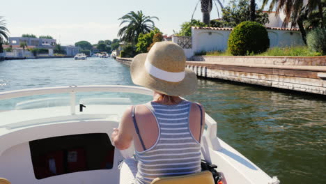 Junge-Frau-Genießt-Einen-Urlaubsort-In-Europa-Schwimmt-Auf-Einem-Boot-Auf-Dem-Kanal-Empuriabrava-Spanien