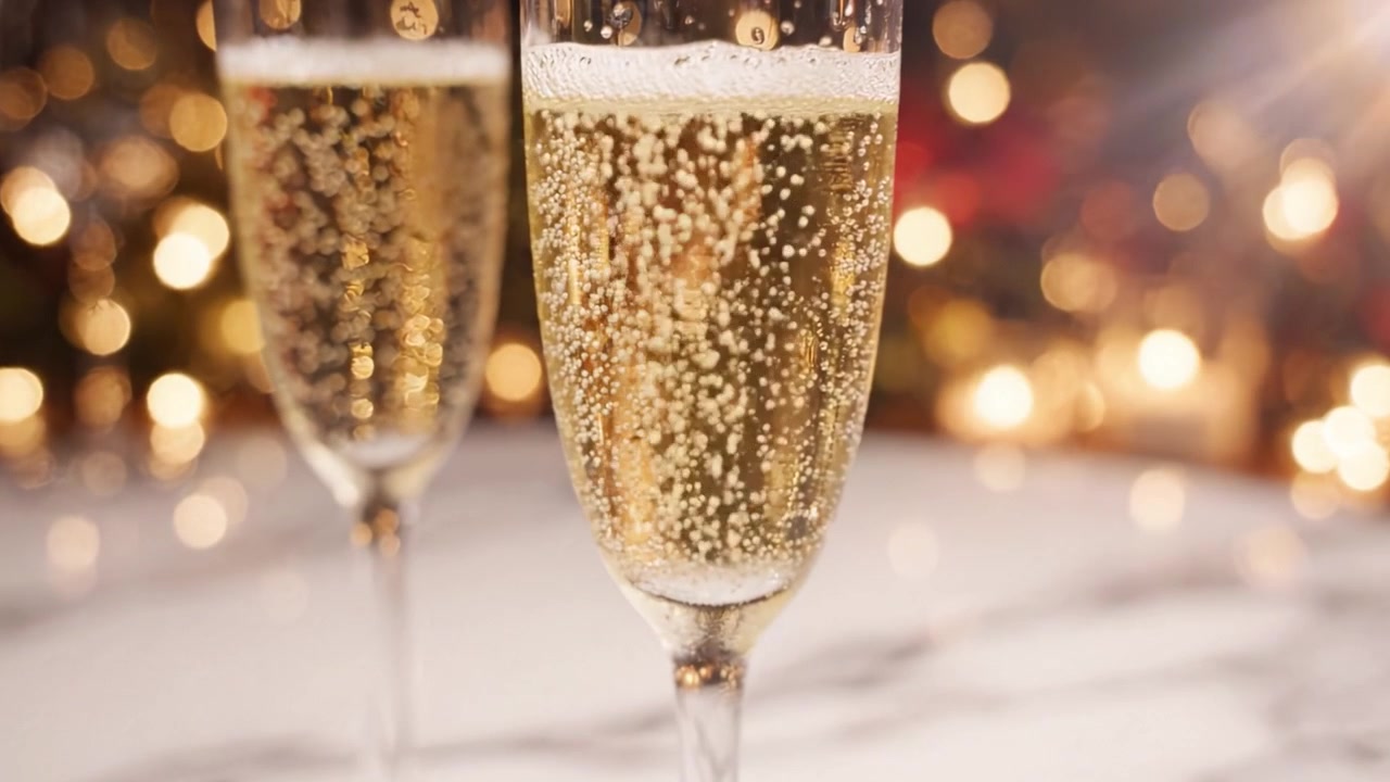 Un brindisi alla celebrazione: calici di champagne scintillanti catturati con eleganza in un'atmosfera festosa con luci bokeh per un momento indimenticabile.