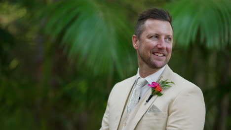 smiling caucasian groom in beige suit waiting for bride in outdoor wedding ceremony, 4k slow motion