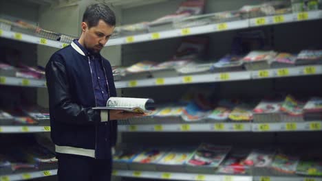 man reading a magazine in a bookstore