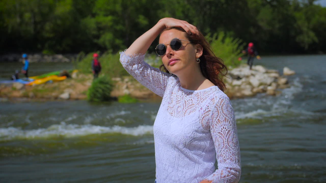 아름다운 소녀의 슬로우 모션 비디오는 야외에서 태양 광선에 반짝이는 곱슬머리를 만집니다.