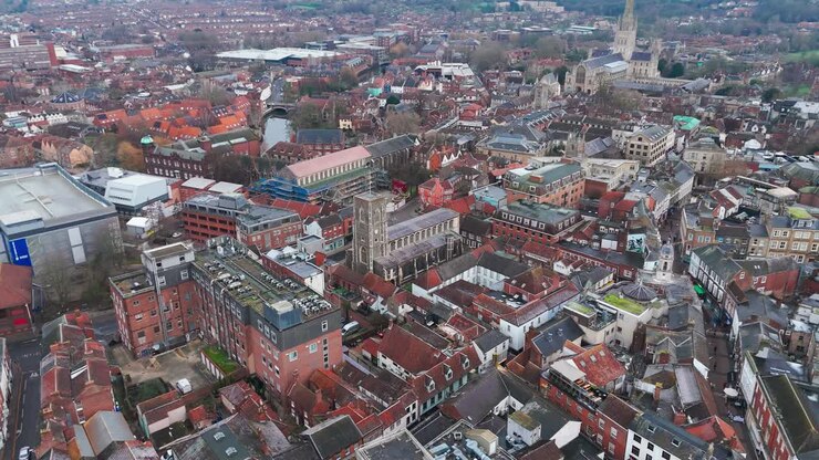 Norwich city, showcasing churches, turrets, streets, and vibrant shops, aerial view