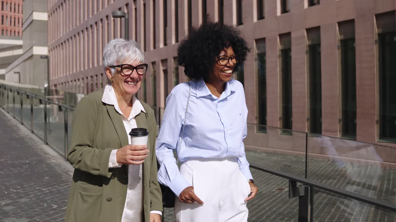 Two Businesswomen Walking and Talking on a City Street