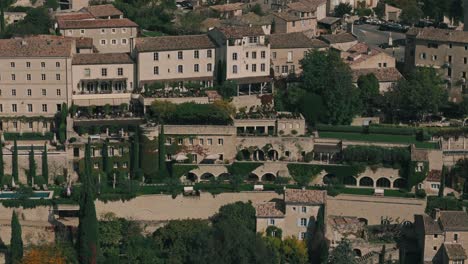 aerial tracking right of gordes, france, showcasing cypress trees and provencal architecture