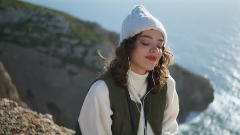 Mujer-Satisfecha-Escuchando-Música-Al-Borde-Del-Acantilado.-Niña-Feliz-Cerrando-Los-Ojos-Descansando