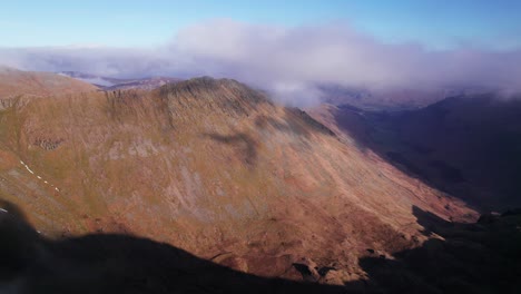 drone shot slowly pushing forward through clouds above a mountain, helvellyn, lake district, cumbria, uk