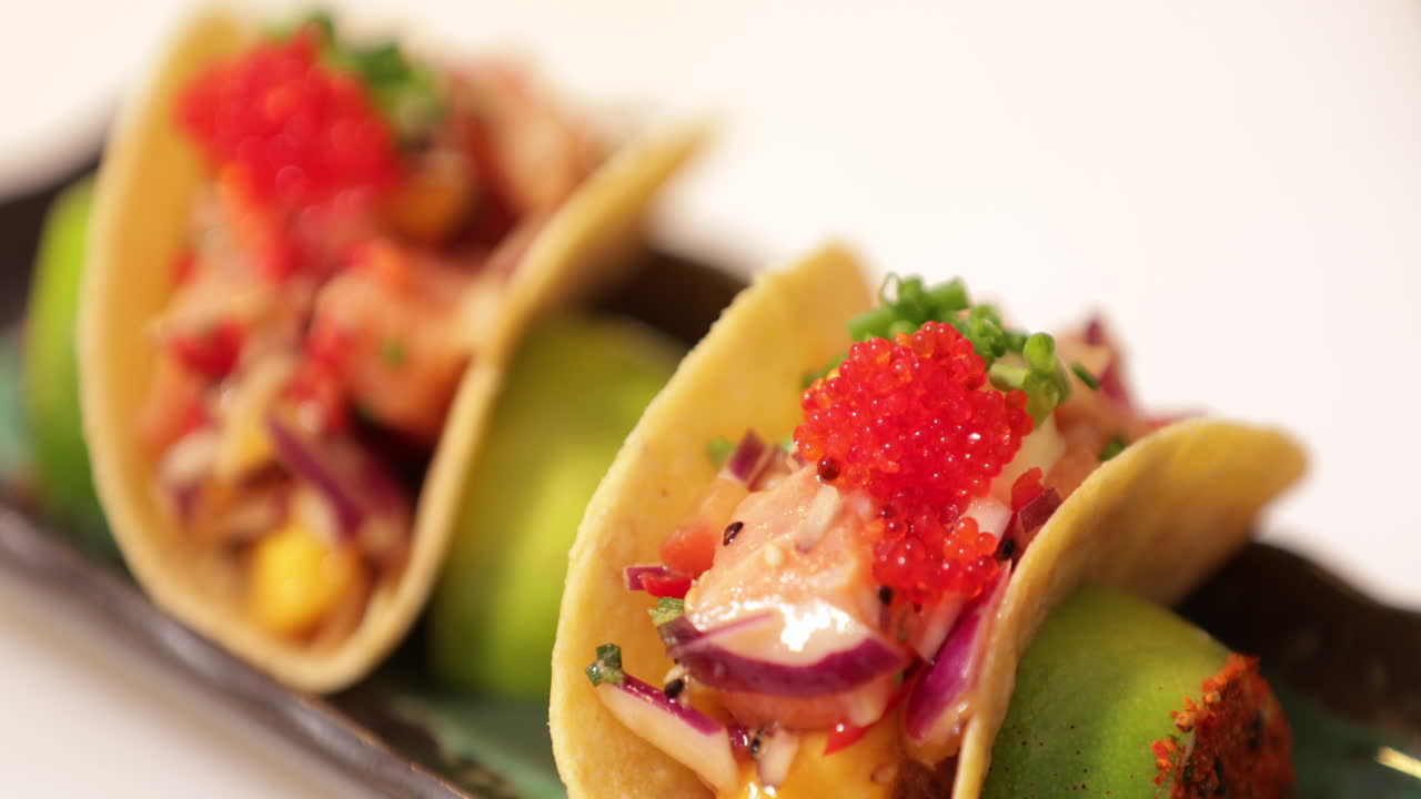 Kok garnerer sushi-tacos med frisk hakket purløg før servering
