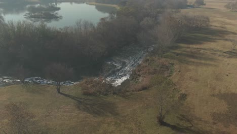 Imágenes-Aéreas-De-Drones-De-Un-Río-Contaminado-Que-Fluye-Junto-A-Un-Lago