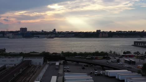 Slow-rise-up-to-a-colorful-sunset,-as-a-bird-flies-to-the-left-in-Hudson-Yards-in-New-York