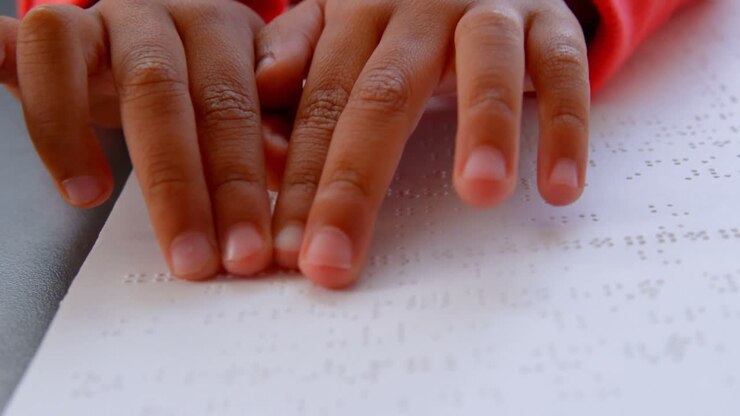 Close-up of blind Asian schoolboy hand reading a braille book in classroom at school 4k