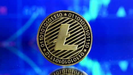 close up of single golden litecoin on a mirroring ground with symolization of rising stock in the background