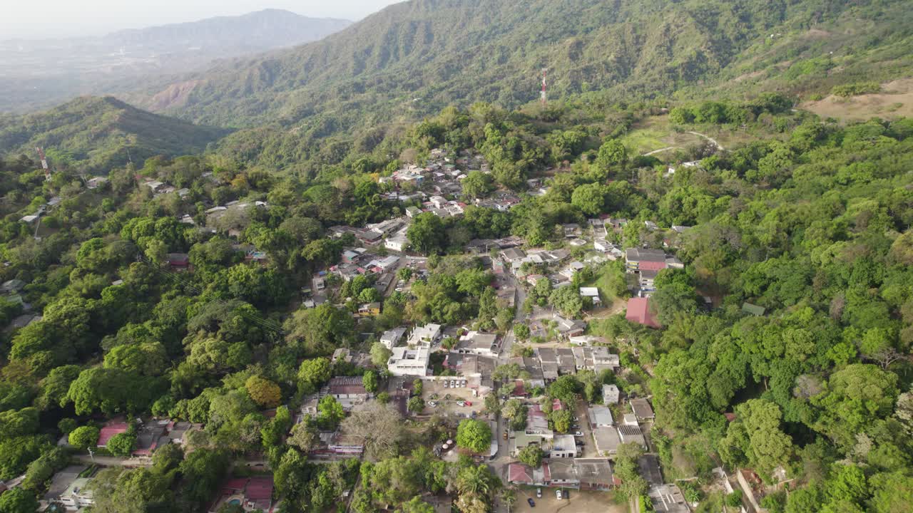 tomada panorámica aérea que establece el pueblo de minca colombia emergiendo de la selva tropical en la ladera de la colina